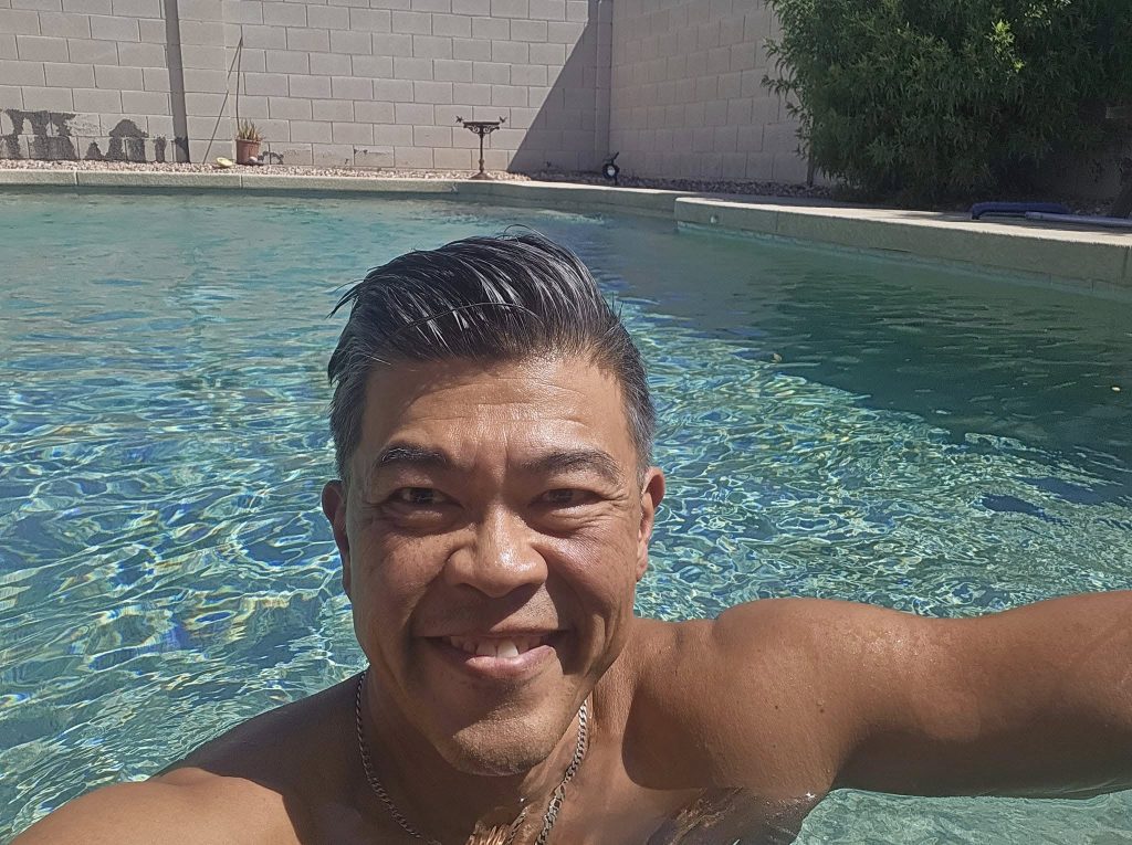Ed enjoying a sunny day in a swimming pool, with sparkling blue water in the background in Simi Valley.