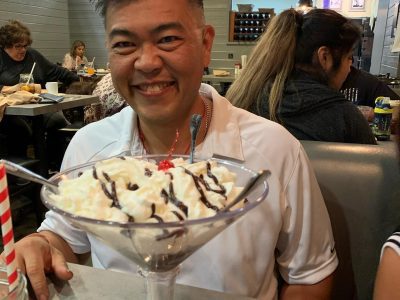 the_best_looking_guy_simi_valley_birthday Ed at Red’s BBQ in Simi Valley celebrating his birthday with a large ice cream sundae topped with whipped cream, chocolate drizzle, and a cherry